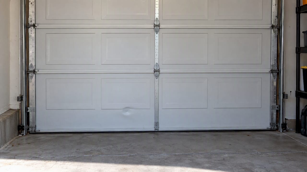 Small rounded dent in a garage door panel